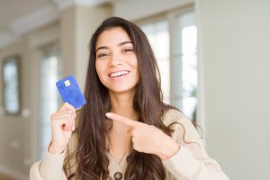 Young Woman Holding Credit Card As Payment Very Happy Pointing With Hand Finger Scaled